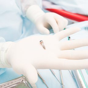 Gloved hand holding a dental implant in Ramsey, NJ