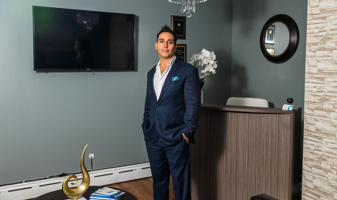 Doctor Vahid standing in dental office waiting room with hands in pockets