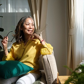 a woman smiling and sitting on a couch