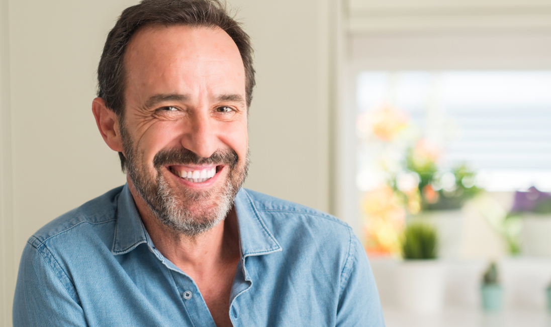 Smiling man in denim shirt with dental implants in Ramsey New Jersey