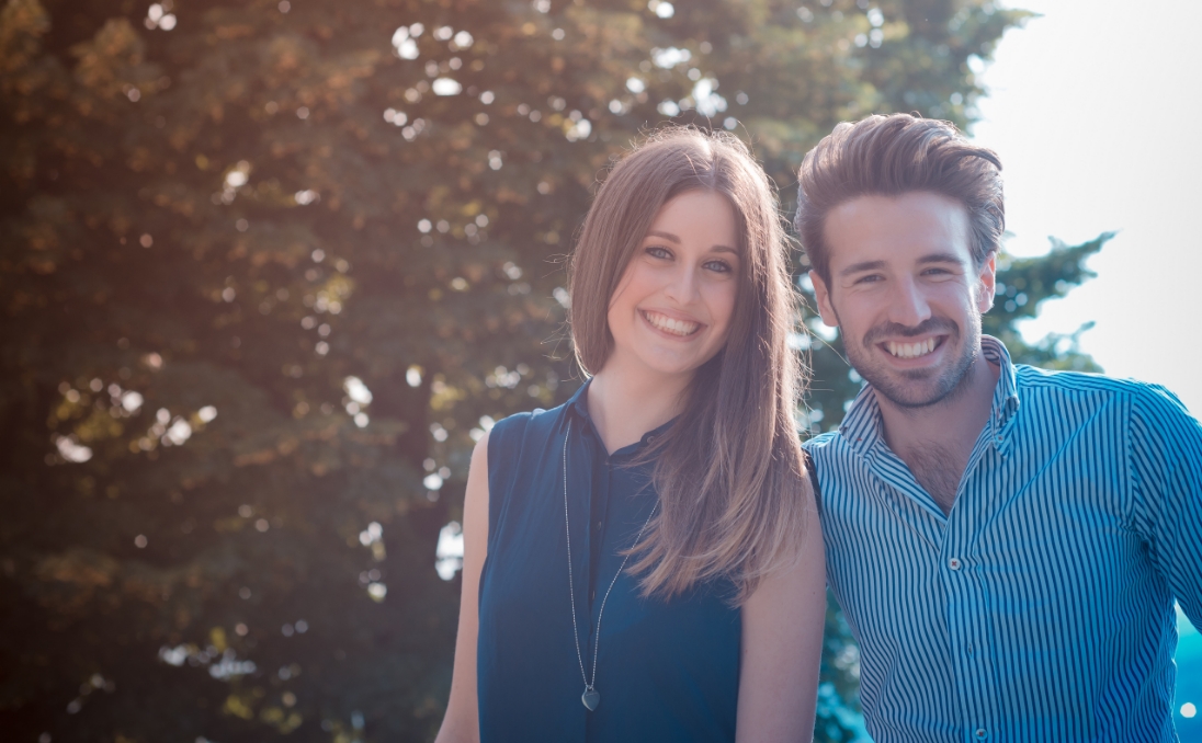 Young man and woman smiling together outdoors
