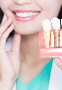 Dentist holding a dental implant model