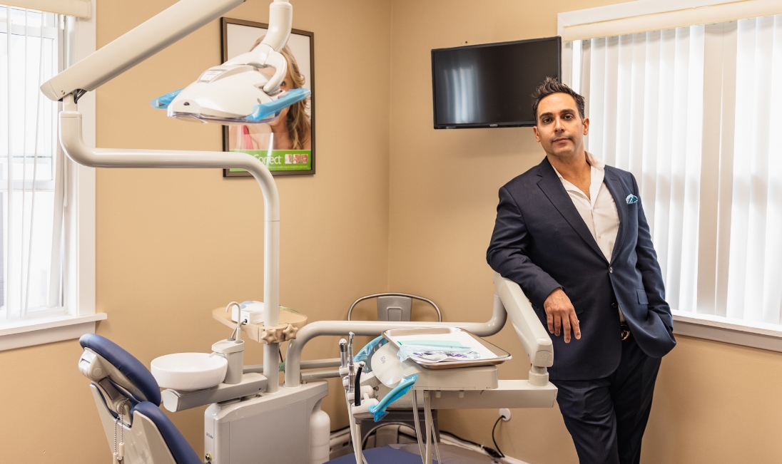 Doctor Vahid leaning against equipment in dental treatment room