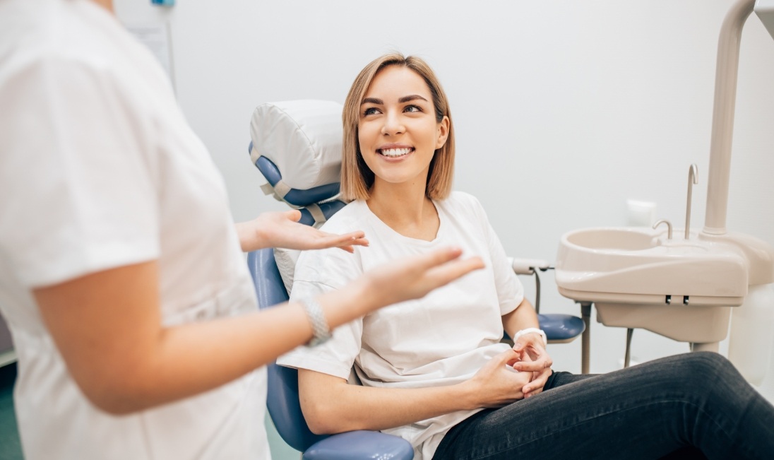 Young woman smiling at her dentist while receiving preventive dentistry in Ramsey