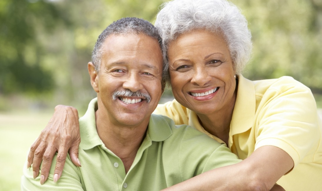 Senior man and woman smiling outdoors after restorative dentistry in Ramsey