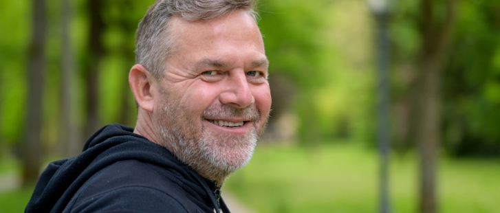 Older man smiling in a forest