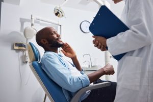 a patient speaking with their dentist about dental implants