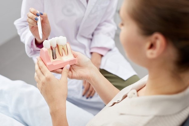 doctor showing patient dental implant